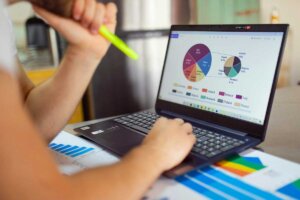 Person at a desk reviewing their 401k charts on a laptop computer.