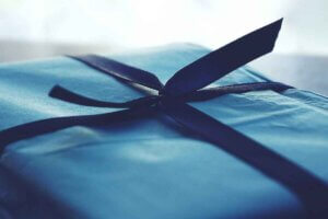 A blue gift package with a blue ribbon on top of it.