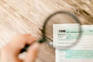 Close up of looking through magnifying glass at tax return.