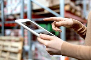 Female manager using a tablet in a warehouse for inventory.